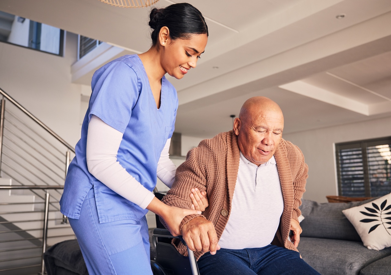 Happy nurse, man in wheelchair and support in nursing home for medical service, physical therapy and retirement. Caregiver, nurse and helping patient with disability, homecare and health assistance
