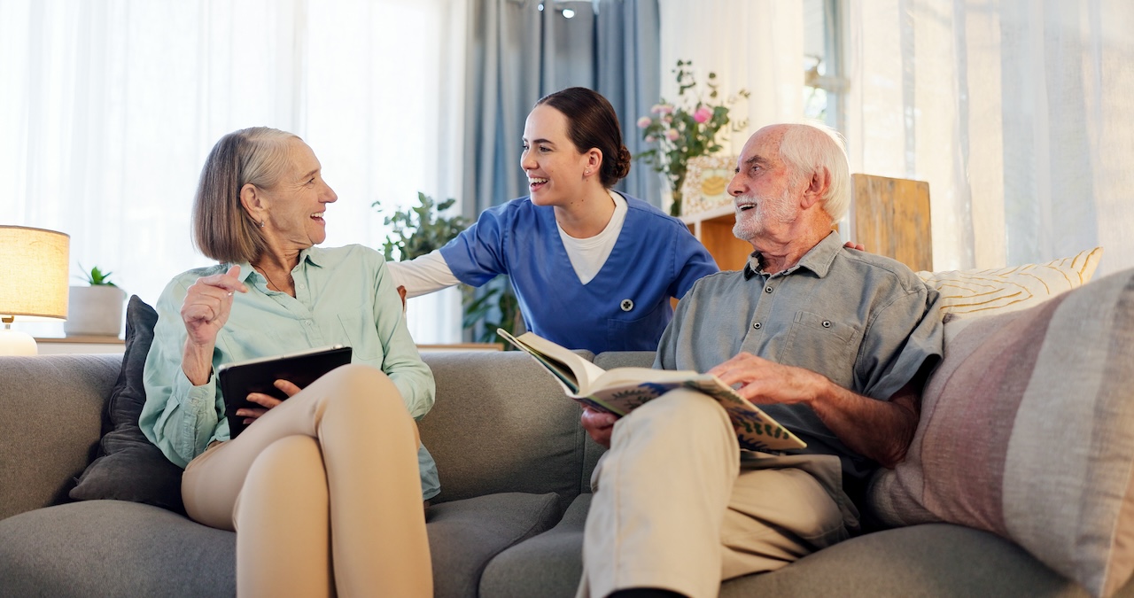 Senior adult couple, care giver and happy on couch in retirement home with fun, care and support.