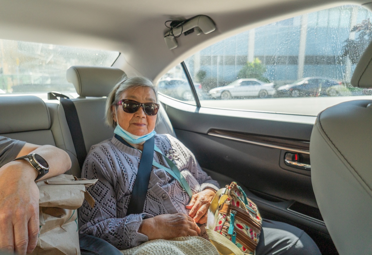 Senior adult woman traveling in the car. Sitting in the back seat of a car.